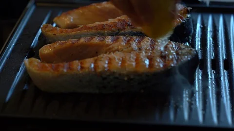 Close up shot of squeezing lemon juice on two salmon steaks Stock Footage 114001302