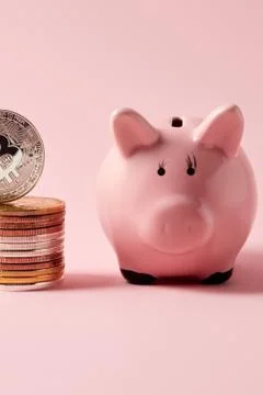 Close-up shot of stack of bitcoins and piggy bank on pink tabletop Foto stock