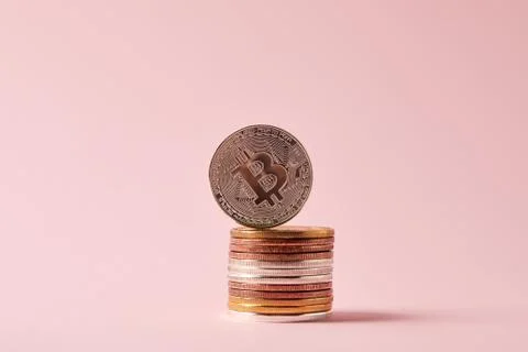 Close-up shot of stack of bitcoins on pink surface 库存照片