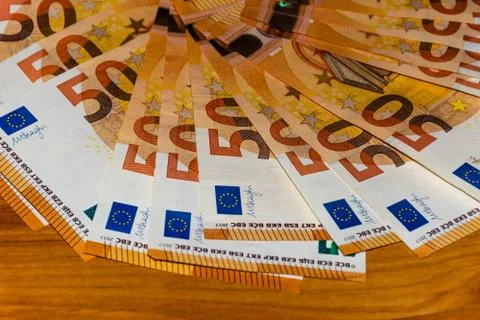 A close-up shot of a stack of many 50 (fifty) euro banknotes on the table Stock Photos