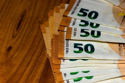 A close-up shot of a stack of many 50 (fifty) euro banknotes on the table Stock Photos