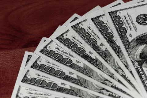 A close-up shot of a stack of several 100 (hundred) US dollars banknotes on t Stock Photos