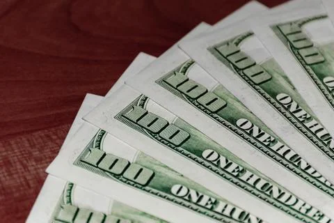 A close-up shot of a stack of several 100 (hundred) US dollars banknotes on t Stock Photos