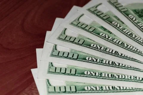 A close-up shot of a stack of several 100 (hundred) US dollars banknotes on t Stock Photos