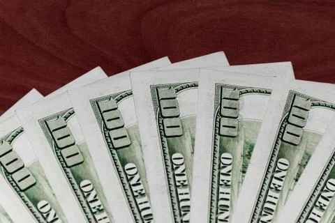 A close-up shot of a stack of several 100 (hundred) US dollars banknotes on t Stock Photos