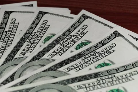 A close-up shot of a stack of several 100 (hundred) US dollars banknotes on t Stock Photos