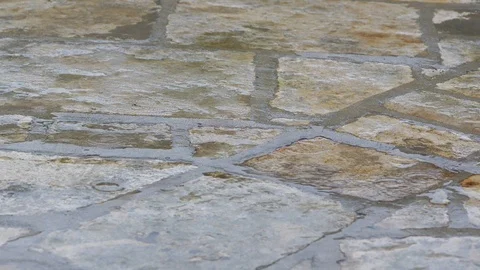 Close up shot of steady rain on stone pavement during daytime. SLOW MOTION Vídeo Stock 103422110