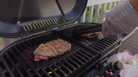 Close up shot of A steak on the grill bbq. Meat steaks grilling and flipping on Stock Footage 314927025