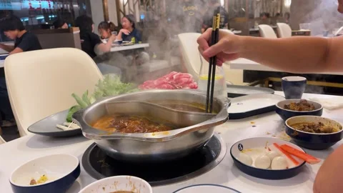 A close-up shot of a steaming Chinese hotpot boiling on a table in a Toronto. Stock-Footage 343675801