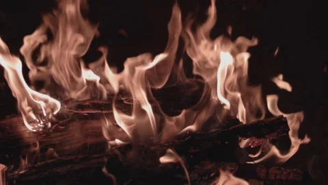 Close up shot stoking real fire in fireplace, with firewood, in slow motion (120 Stock Footage 88709343