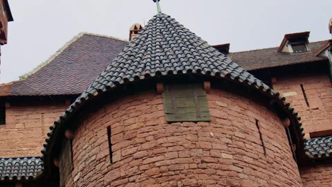 Close up shot of a stone castle wall and tower with tiled roofs, small windows Stock Footage 311886337