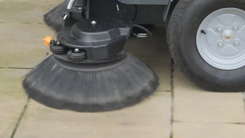 A close up shot of the street sweeping machine cleaning the street. Stock Footage 303459539