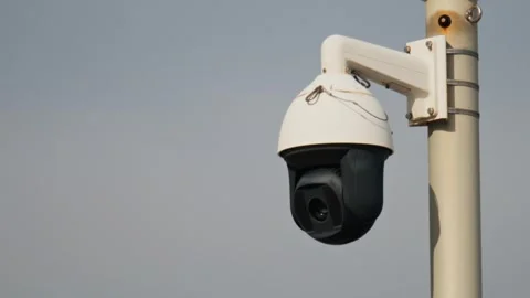 A close up shot of a surveillance camera on top of a pole with a clear sky .. Stock Footage 339472111