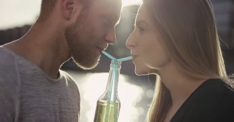 Close shot of sweet couple drinking lemonade with a straw Stock Footage 79389899
