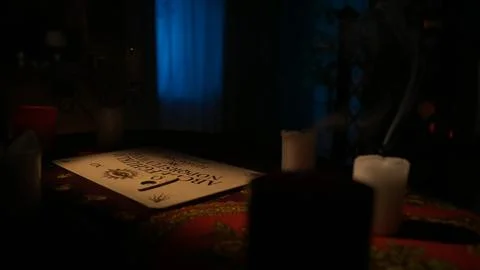 Close up shot of the table with many blown out candles and spirit ouija board Foto stock