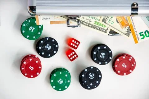 A close-up shot of a table with poker chips, dice, and a silver case full o.. Stock Photos