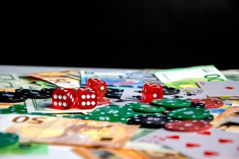 A close-up shot of a table with red dice, poker chips, and Euro banknotes s.. Stock Photos