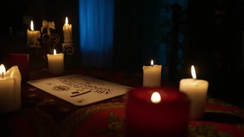 Close up shot of the table in the room with many candles and spirit ouija board Vídeos de archivo 247985166