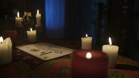 Close up shot of the table in the room with many candles and spirit ouija board Stock Footage 248007242