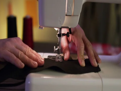 Close up shot of a tailor behind a sewing machine Stock Footage 84004556