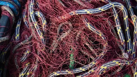 Close-up shot of tangled fishing nets and ropes in a pile, cinematic footage. 動画素材 339644738
