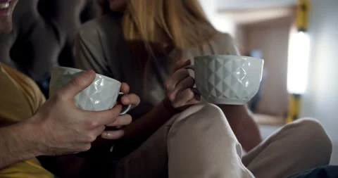 A close up shot of tea cups in the hand of a couple in the bedroom. Slow motion. Stock Footage 146730029