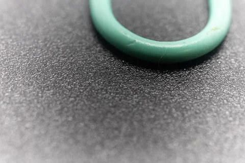 A close-up shot of a teal-colored ring on a textured gray surface. Stock Photos