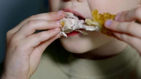 Close up shot of a teenager's mouth, a child starving to eat poultry meat, which Stock Footage