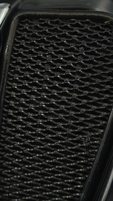 A close-up shot of a textured black plastic car radiator grille Stock Footage 336710474