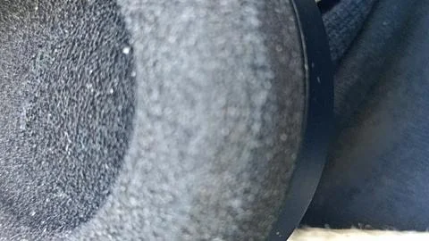 A close-up shot of a textured black surface featuring a circular element and  Stockfoto's