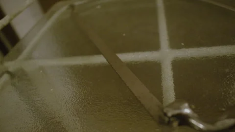 A close-up shot of a thin curved saw resting on a glass surface. Stock Footage 301159119