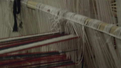 A close up shot of threads moving in an obsolete wooden weaving machine. Stock Footage 103261093