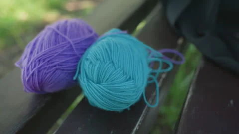 Close up shot of three colorful woolen thread balls in purple turquoise and 動画素材 345840772