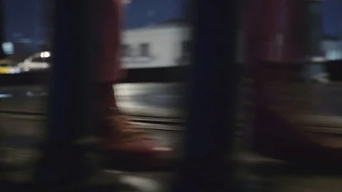 Close-up shot through the railing of walking legs in red pants in red sneakers  Stock Footage 102437834