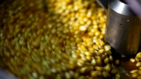 Close up shot of tiny dry corn seeds mixing with caramel cheese sweet flavoured  Stock Footage 137541521