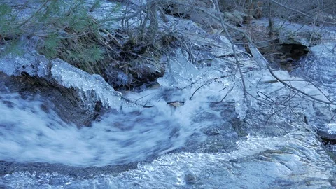 A close up shot of a tiny stream of strong current. There are somr iced 스톡 동영상 124297413