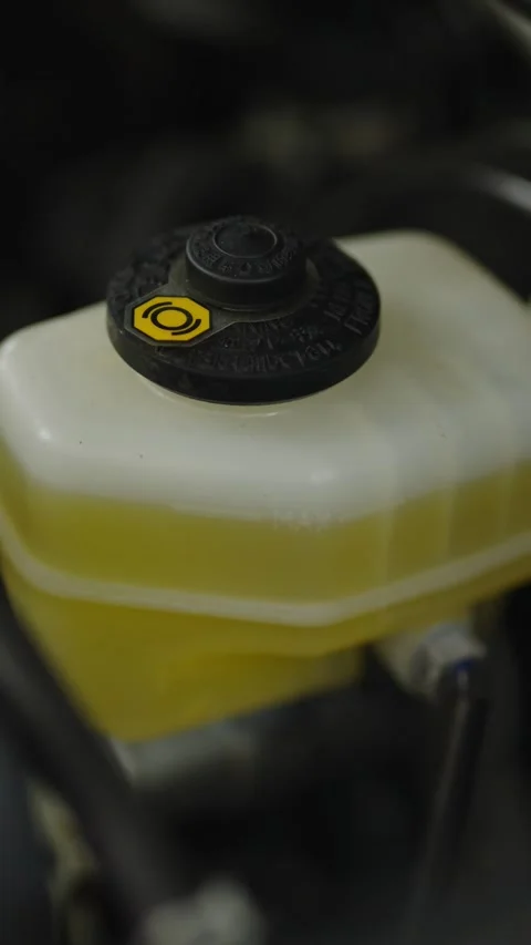 A close-up shot of a translucent white plastic brake fluid reservoir with Stock Footage 336710509