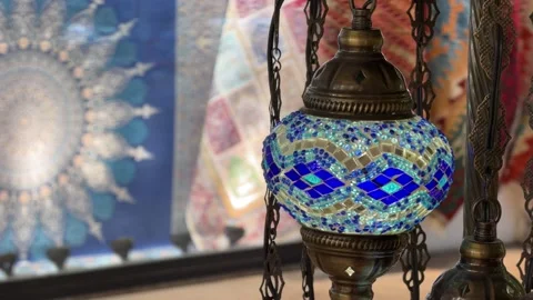 Close-up shot of an Turkish mosaic lamp casting a glowing light in a bazaar Видео 340154713