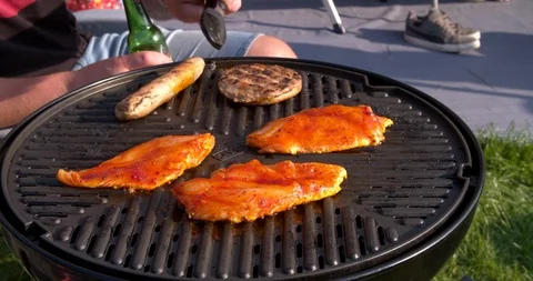 Close up shot turning of meat at a coal fired barbecue Vídeo Stock 111135662
