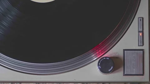 Close-up shot of a turntable being turned off. The platter slows to a halt, a Vídeo Stock 303343031