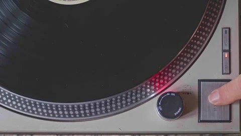 Close-up shot of a turntable being turned on and started. The needle drops on Stock-Footage 303344141