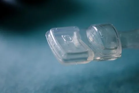 A close-up shot of two clear plastic pieces on a blue surface. Stock Photos