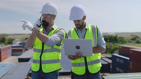 Close up shot two foreman or cargo container workers work with laptop Stock Footage 146436195
