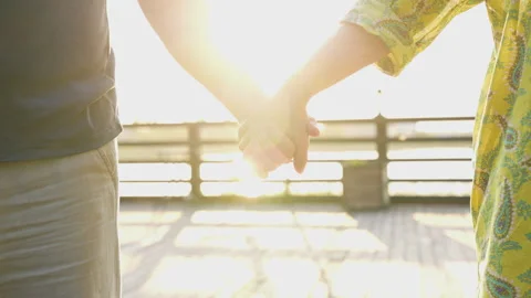 Close up shot of two hands holding each other on the sunset outdoors Stock Footage 247518231