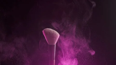 Close up shot of two makeup brushes being rubbed together and scattering pink Stock Footage 194395469