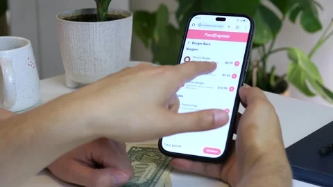 Close-up shot of two people placing a food order together on a phone, discussing Stock Footage 315430797