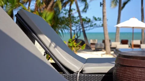 Close up shot of two white lounge chairs with cushions, side table and Stock Footage 106344631