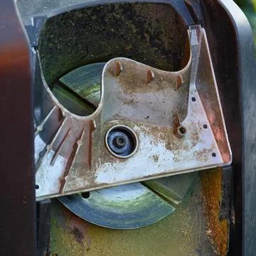 A close-up shot of the underside of a garden shredder showing the metal cutti Stock Photos