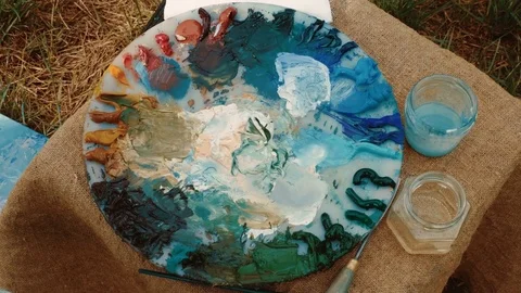 Close-up shot of unknown woman's hand stirring oil paints using fingers. 4K 库存影片 79372425