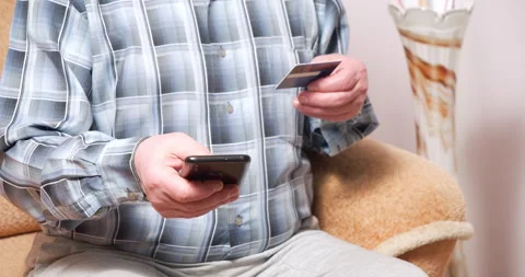 Close-up shot of unrecognizable elderly man holding smartphone and credit card Stock Footage 151021742